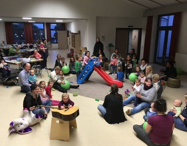 Viele Kinder und Erwachsene spielen mit Spielzeug.