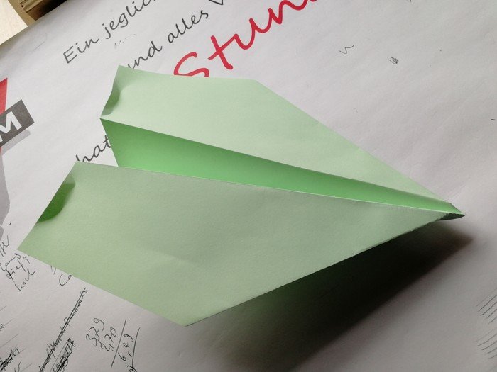 Grünes Papierflugzeug.
