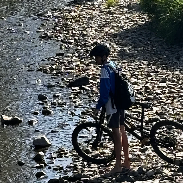 Radfahrer in einem Flussbett.