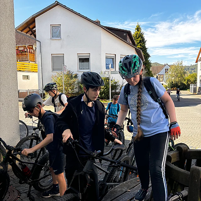 Jugendliche mit Fahrrädern auf der Straße.