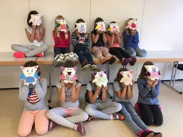 Kinder mit bemalten Masken.