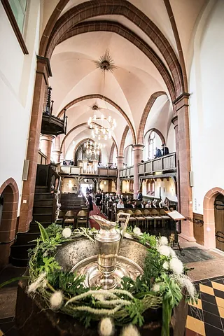 Kircheninnenraum mit Holzempore und Chor.
