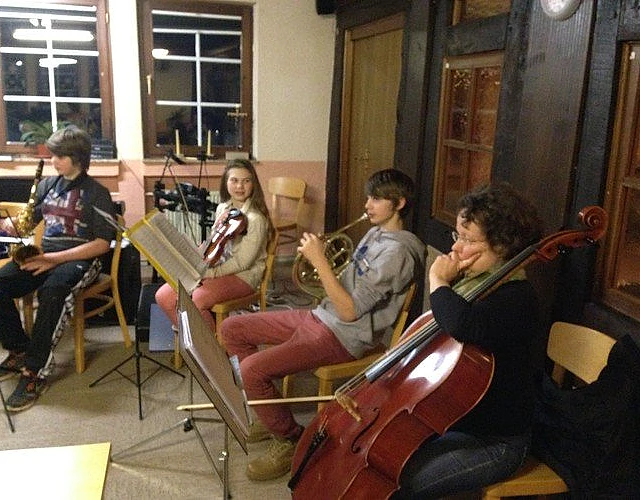 Jugendliche spielen Streichinstrumente.