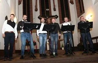 Männliche Musikgruppe tritt in Kirche auf.