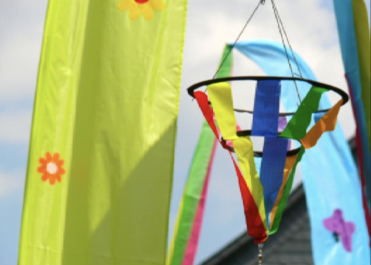 Bunte Bänder und Deko im Freien vor blauem Himmel.