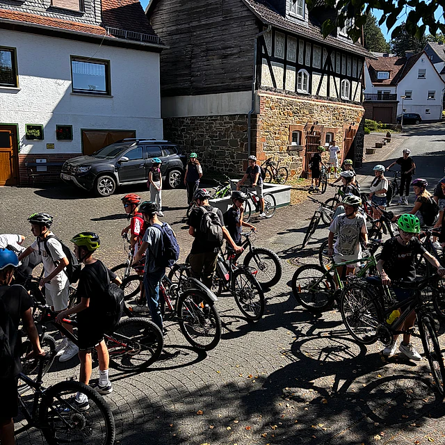 Viele Fahrräder und Menschen in einem Dorf.