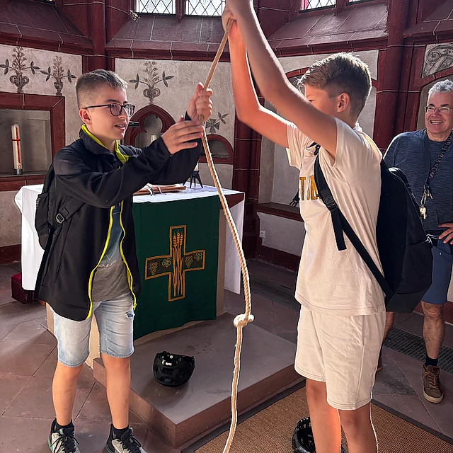 Jugendliche ziehen an Glockenseil.