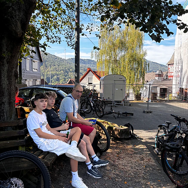 Jugendliche sitzen auf einer Parkbank.