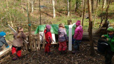 Kinder spielen in einem Waldlager.