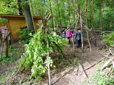 Waldspielplatz mit Ästen und Blättern.